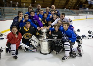 Framingham Youth Hockey Peewee ''A'' Team with coaches Phil Idelson (left), Joe MacIness (center, back), and Charlie Stefanini (right), were lucky enough to be on the ice when the cup arrived at Loring Arena.