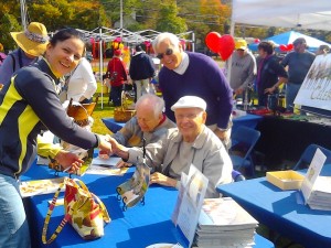 Judy Jackson gets copy of the ''CELEBRATION 2012'' calendar autographed by Mr. February at the First Parish in Framingham's annual ''Pies On The Common'' fair October 15, 2011